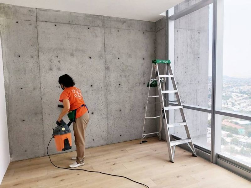 Colaborador de ThinkFix limpiando un ventanal con vista a la ciudad